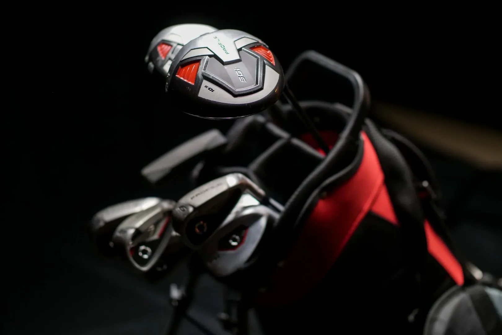 Silver golf clubs in black and red golf club bag