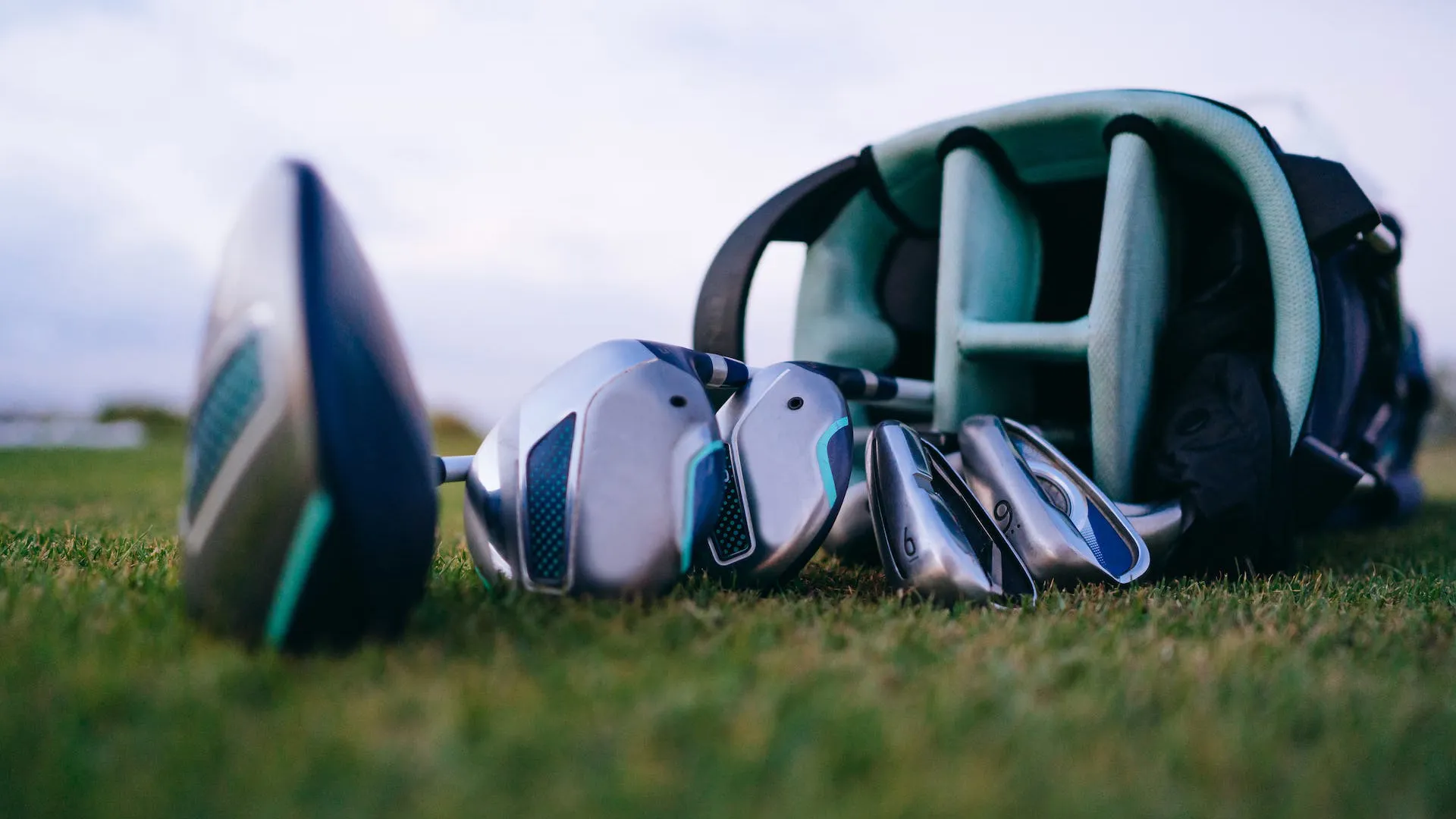 golf club set laying on golf course grass